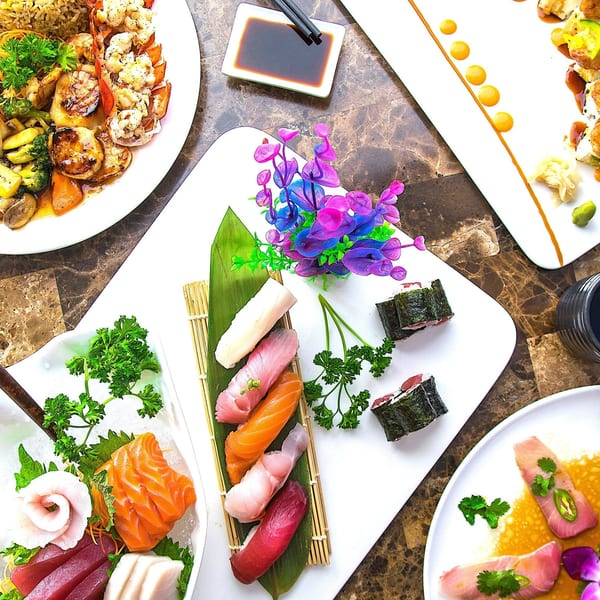Assortment of Japanese dishes including sushi, sashimi, and a seafood and vegetable stir-fry.